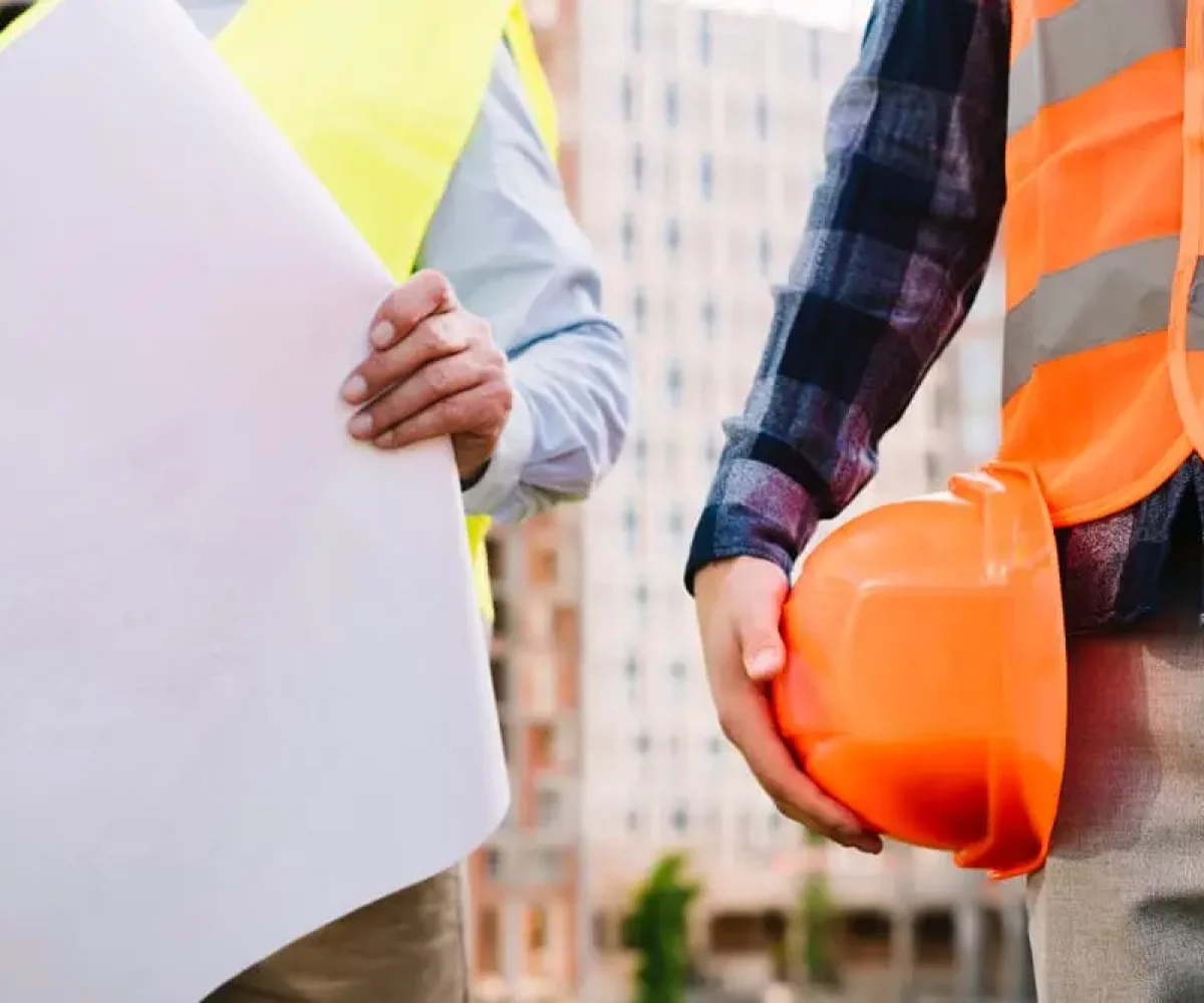 Bauarbeiter mit Bauplan auf der Baustelle vor der Baureinigung