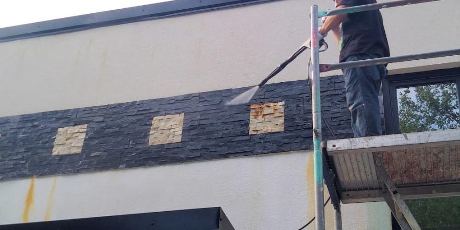 Fassadenreinigung mit Hochdruckreiniger zur Entfernung von Verschmutzungen an einer Gebäudefassade