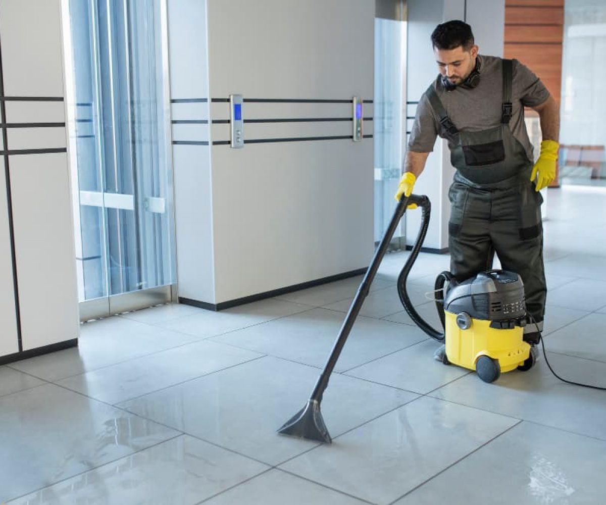 Grundreinigung eines Fliesenbodens mit Reinigungsgerät in einem gewerblichen Innenraum