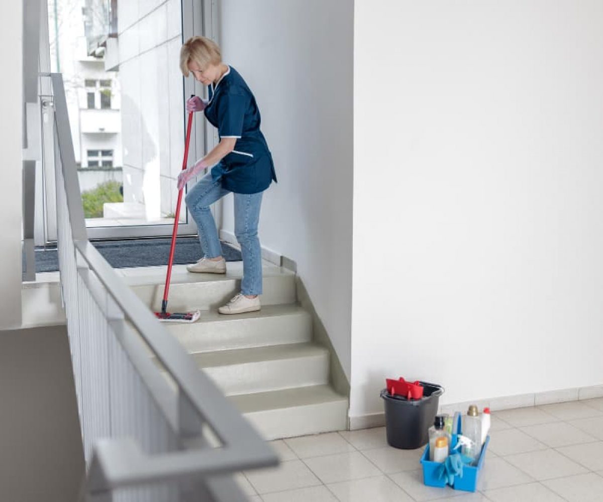 Treppenhausreinigung mit Wischmopp zur Reinigung von Treppenstufen in einem Mehrfamilienhaus