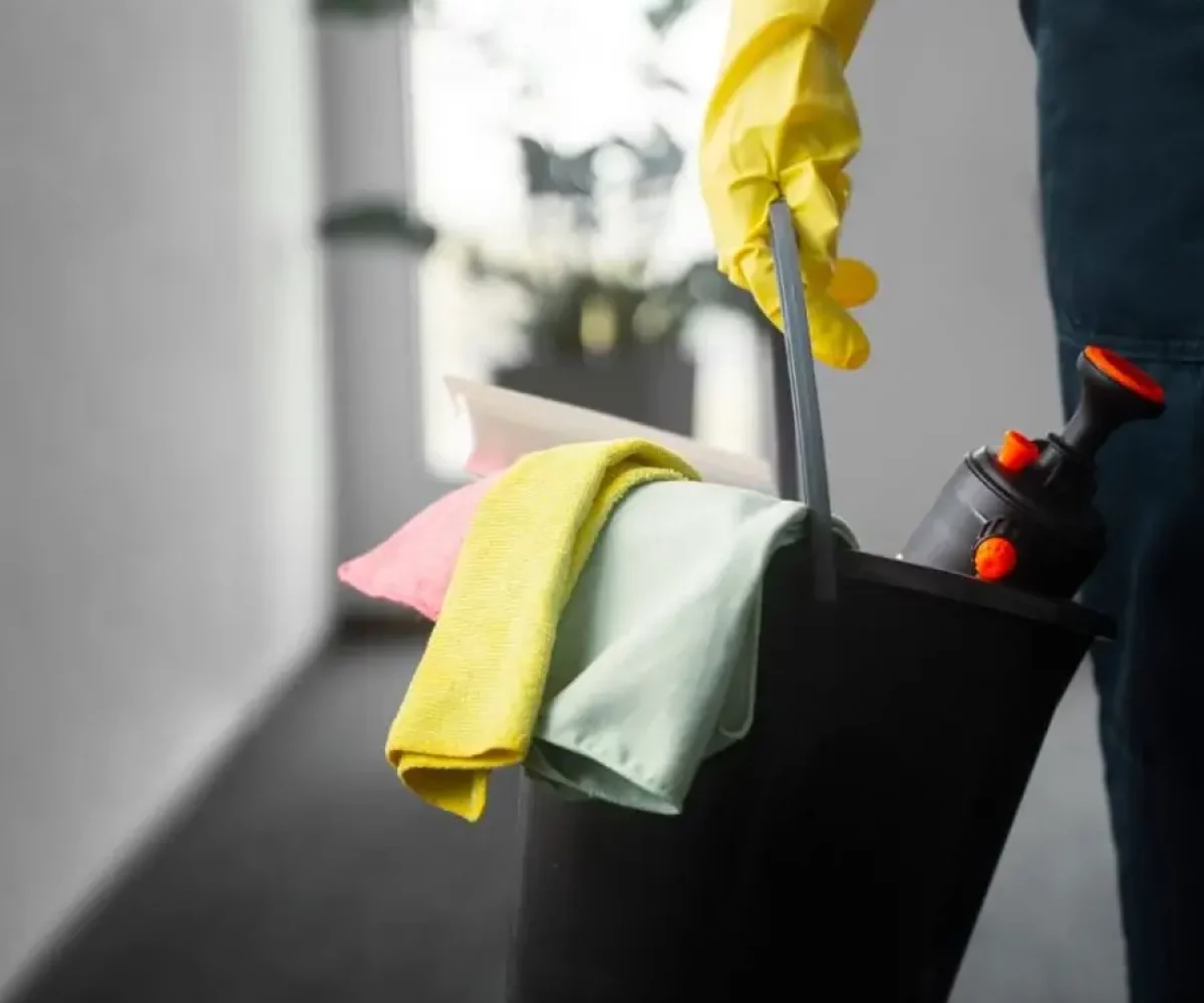 Unterhaltsreinigung mit Reinigungseimer, Tüchern und Sprühflasche für regelmäßige Pflege von Innenräumen